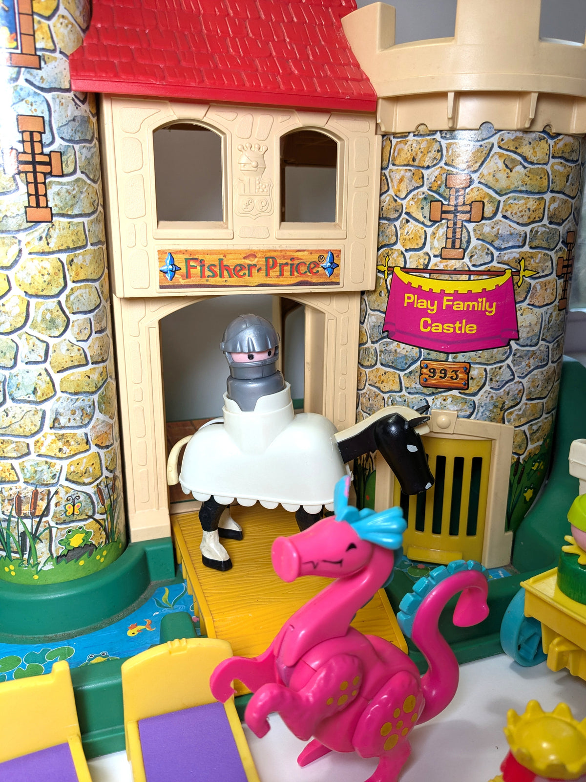 Fisher-Price toy castle with a knight on a horse and a dragon, featuring the Fisher-Price logo.